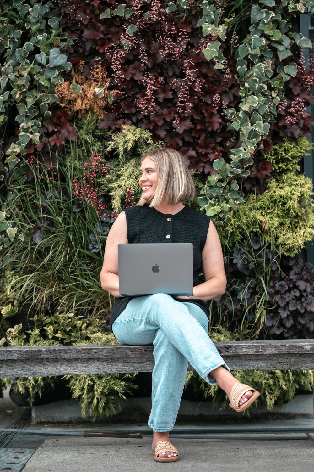 Rachael Smith sitting outdoors with her laptop